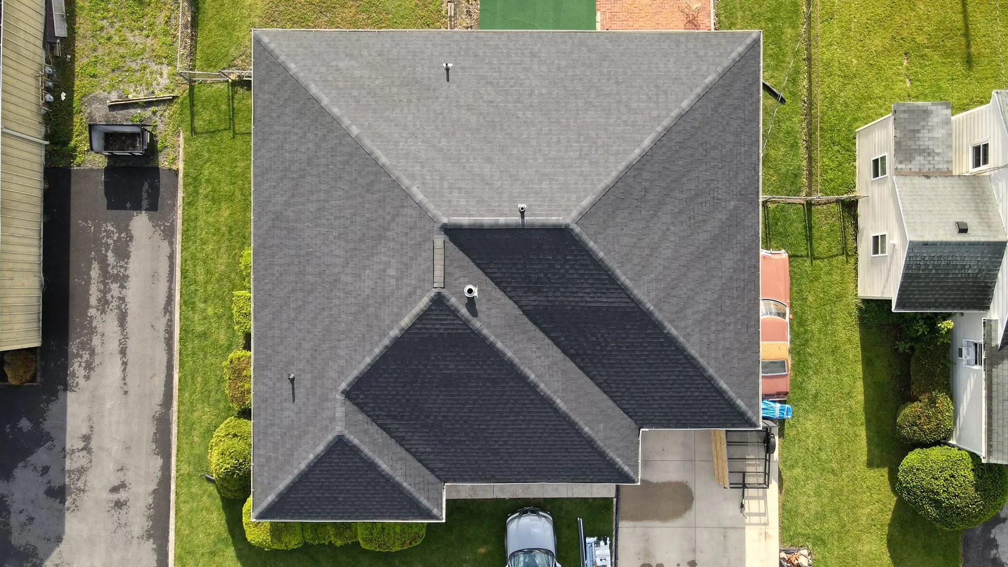 Top-down drone view of a new cross-hip shingle roof