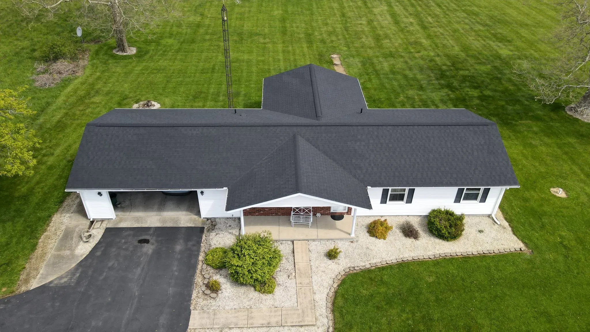 Drone view of a split-level home with a new black shingle roof